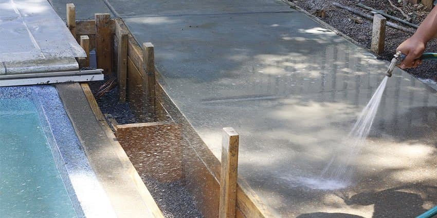 Concrete curing process showing water curing method on a freshly poured slab